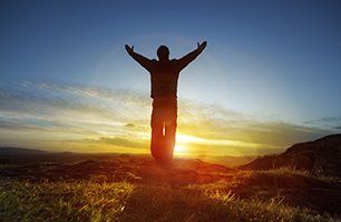 Silhouette of a man with hands raised