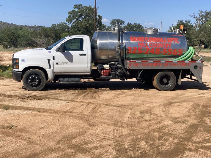 A white truck is parked in a dirt field.