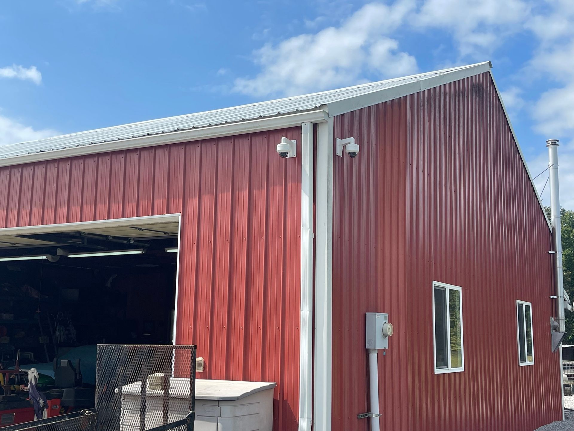 A red barn with a white roof and a large garage door.