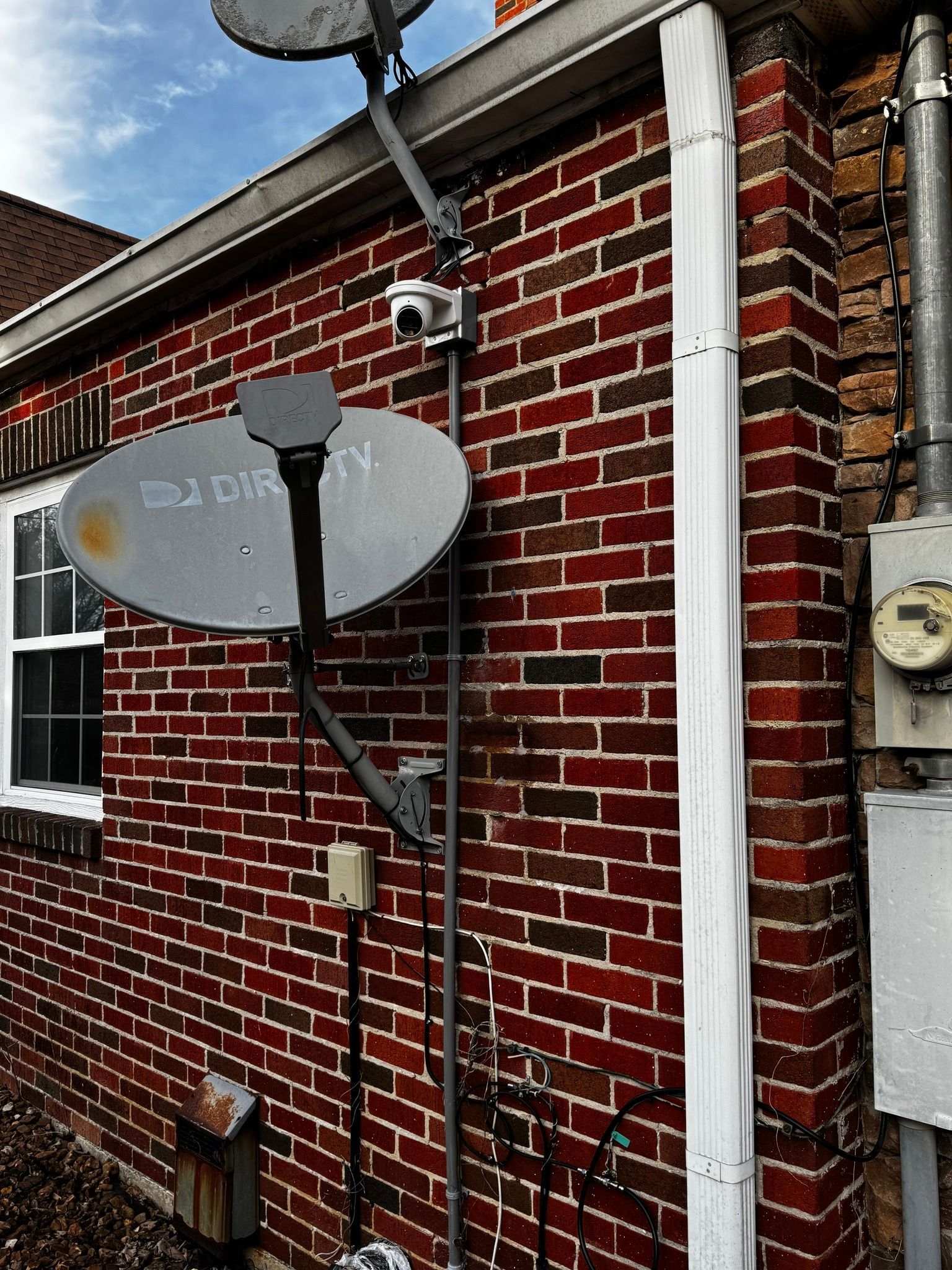 A satellite dish on the side of a brick building