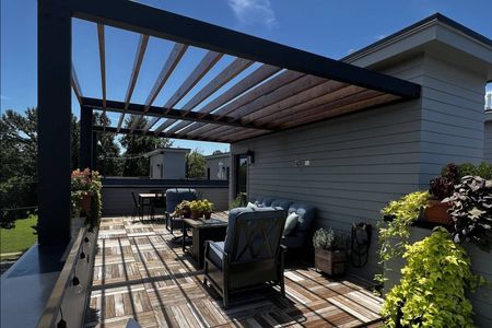 A patio with chairs and a table under a pergola.