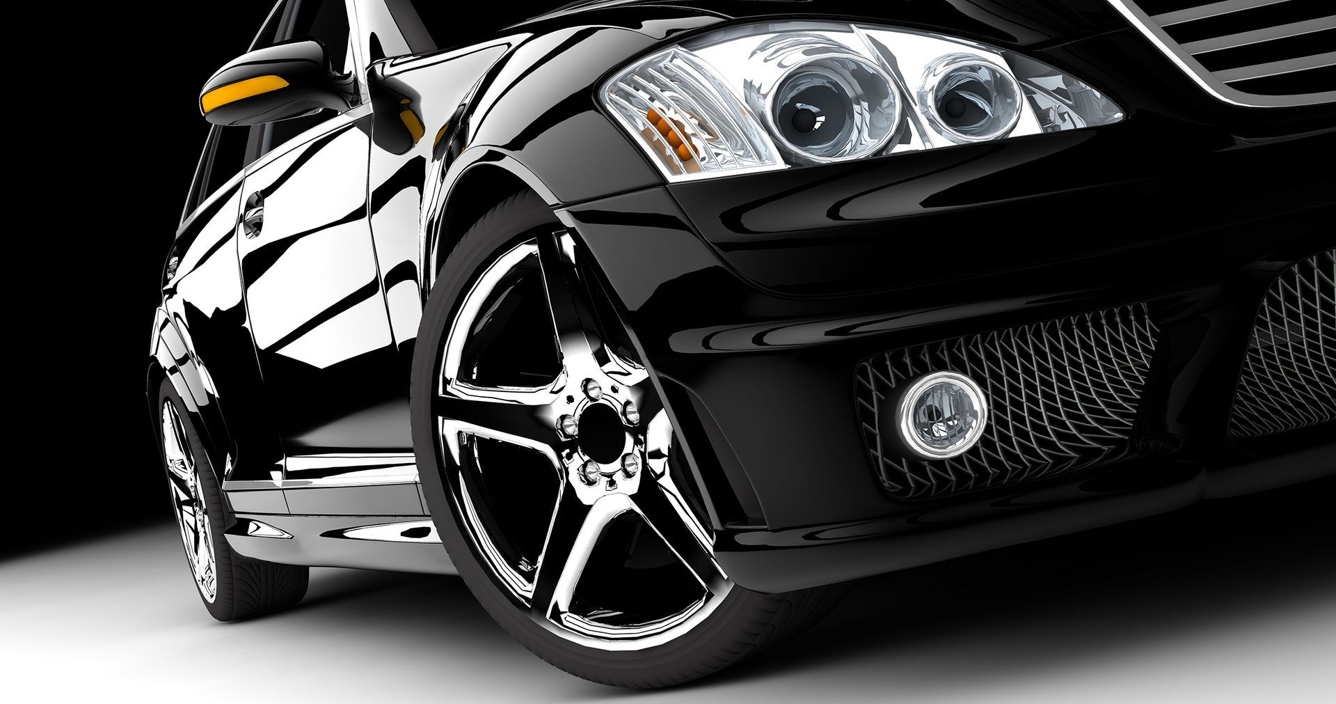 A close up of a black car with chrome wheels.