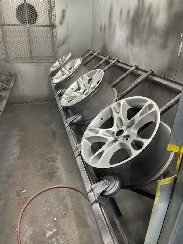 A bunch of wheels are sitting on a rack in a room.