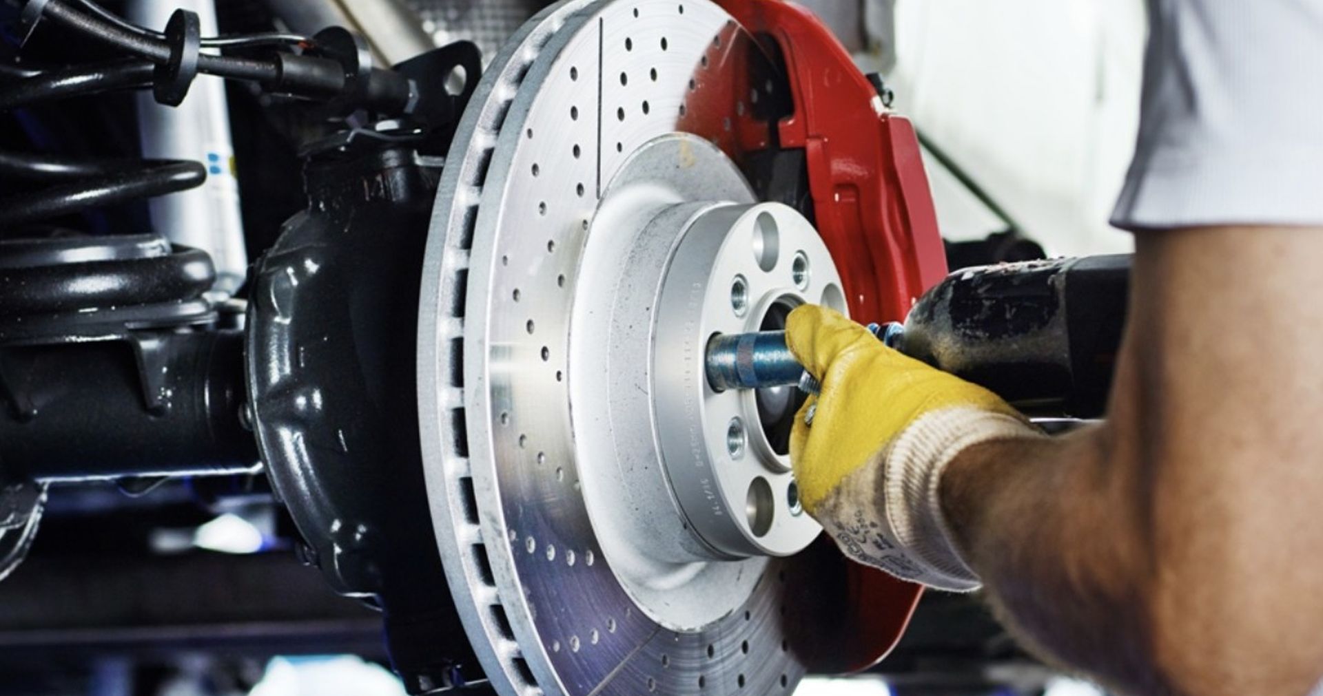 A man is working on a brake disc on a car.