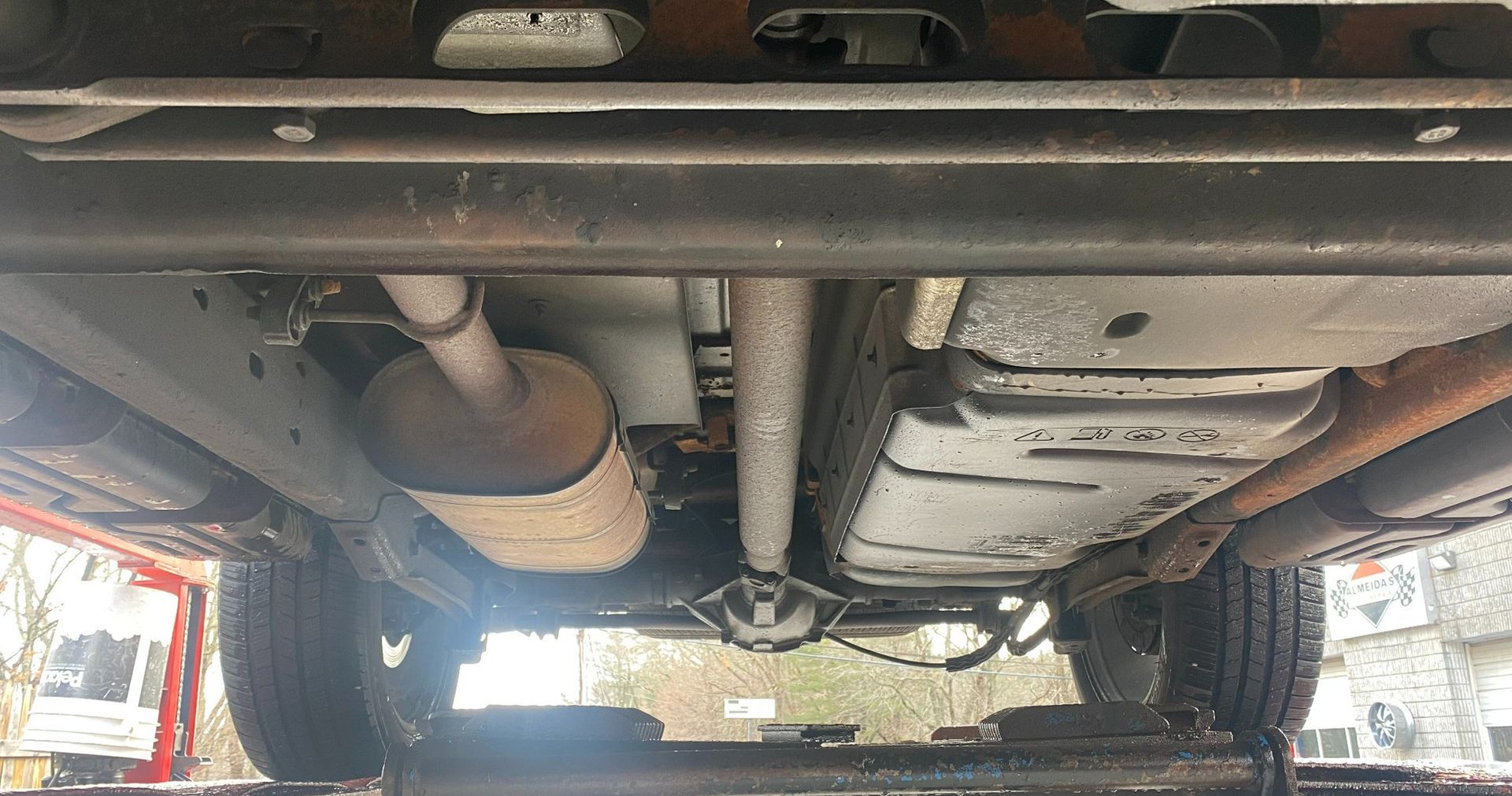 A close up of the underside of a car on a lift.