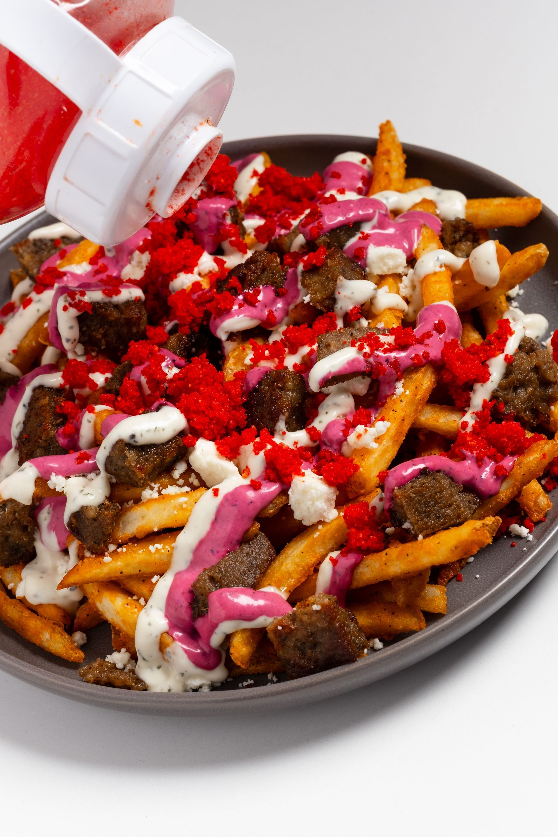 A close up of a pita wrap filled with meat , vegetables and sauce.