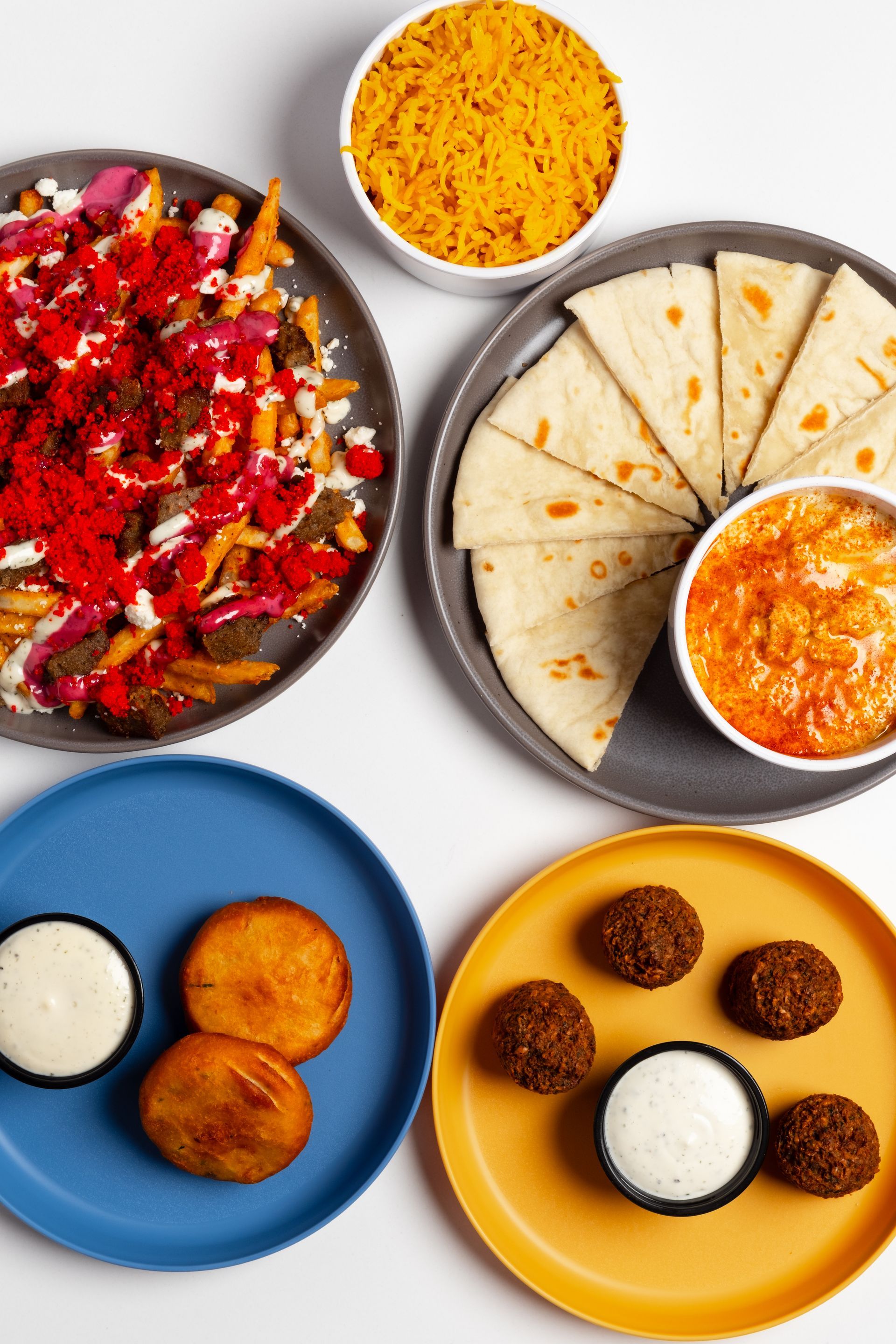 A table topped with plates of food and a burrito.