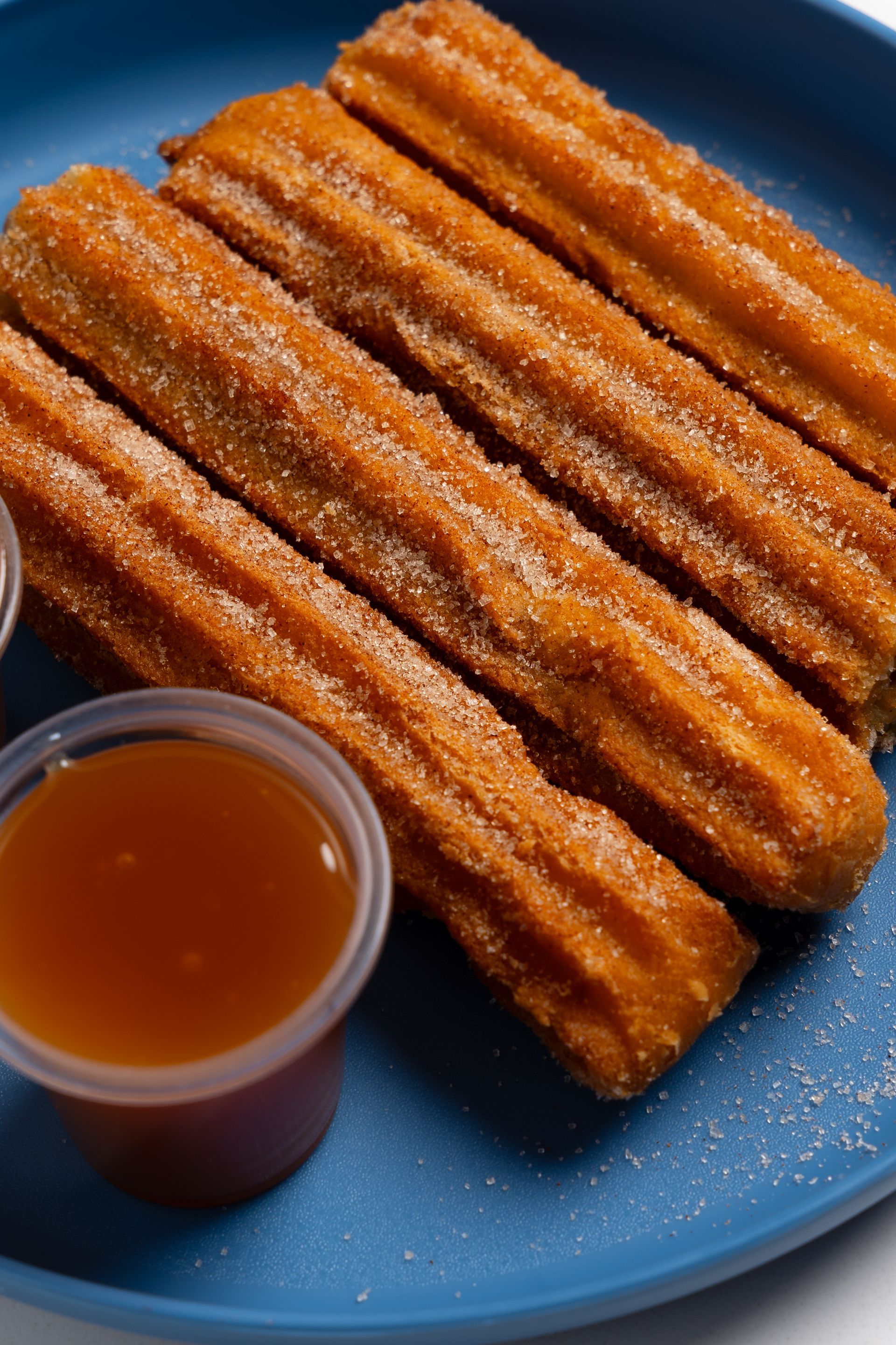 A person is holding a bowl of food in front of a neon sign.