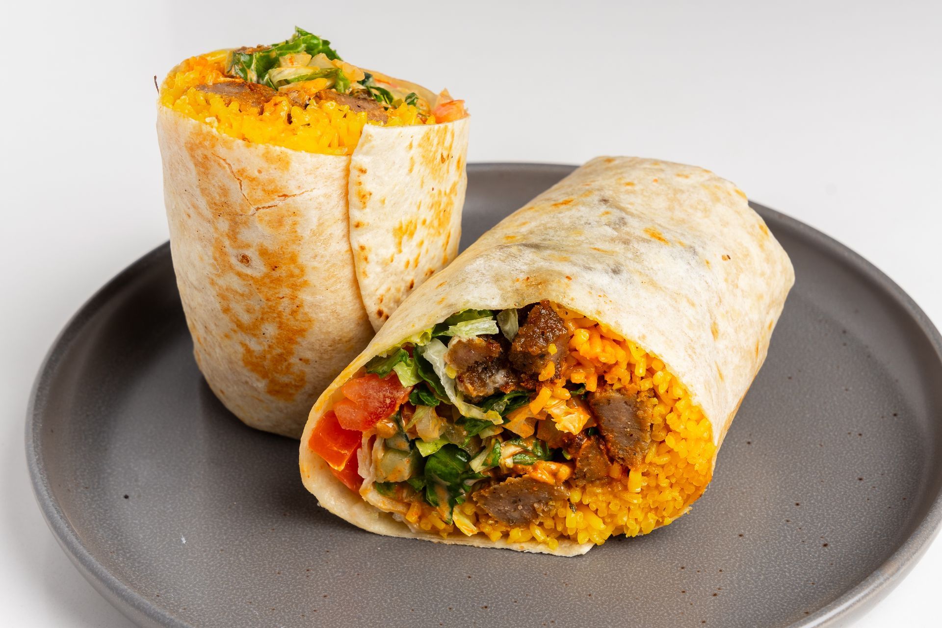 Three aluminum pans filled with different types of food are sitting on a table.