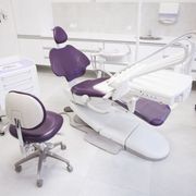 A purple and white dental chair in a dental office
