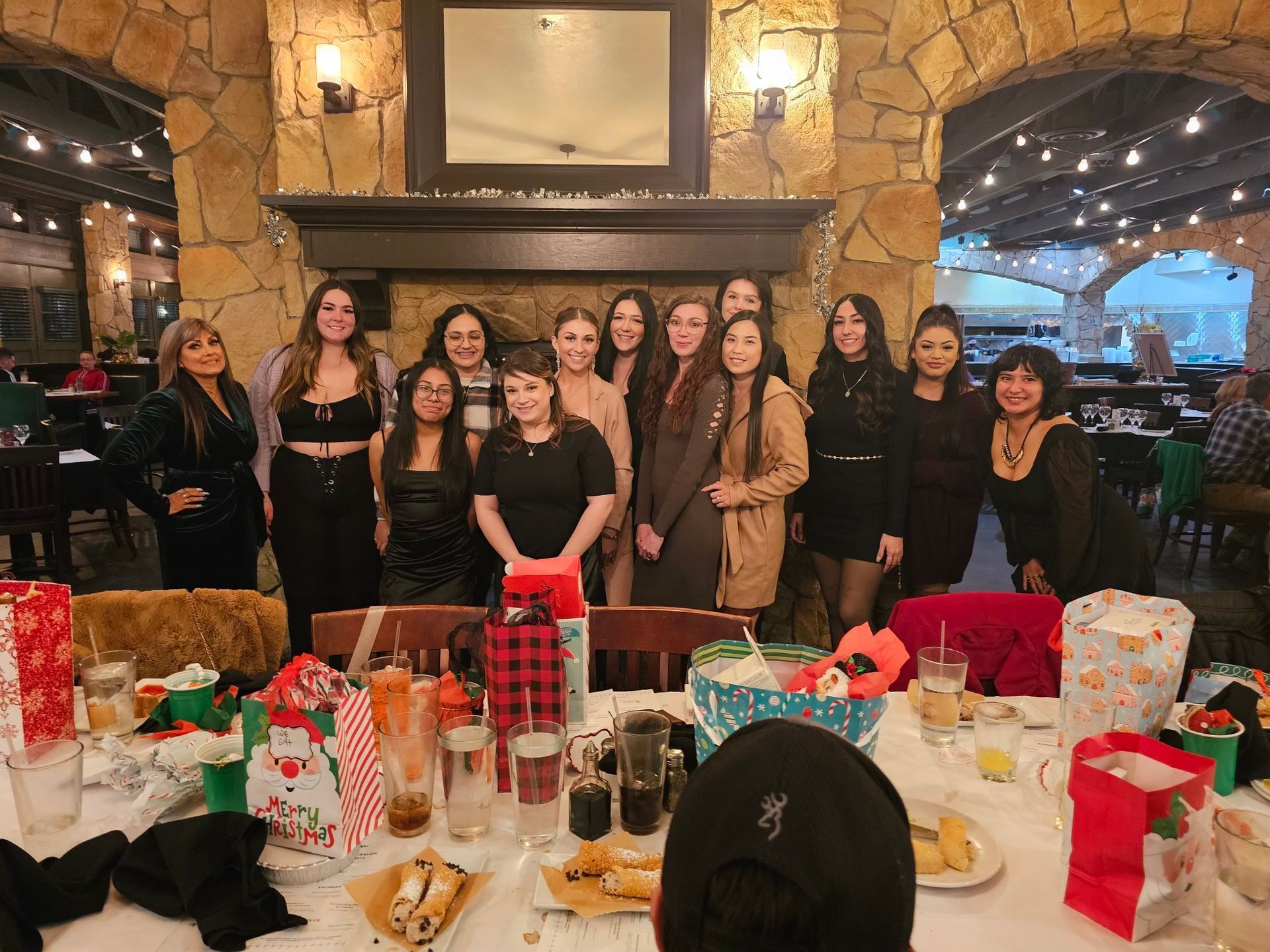 a group of women are standing around a table in a restaurant .