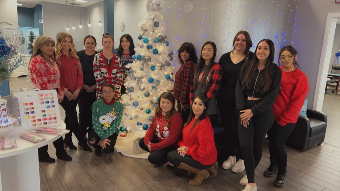 a group of women are posing for a picture in front of a christmas tree .