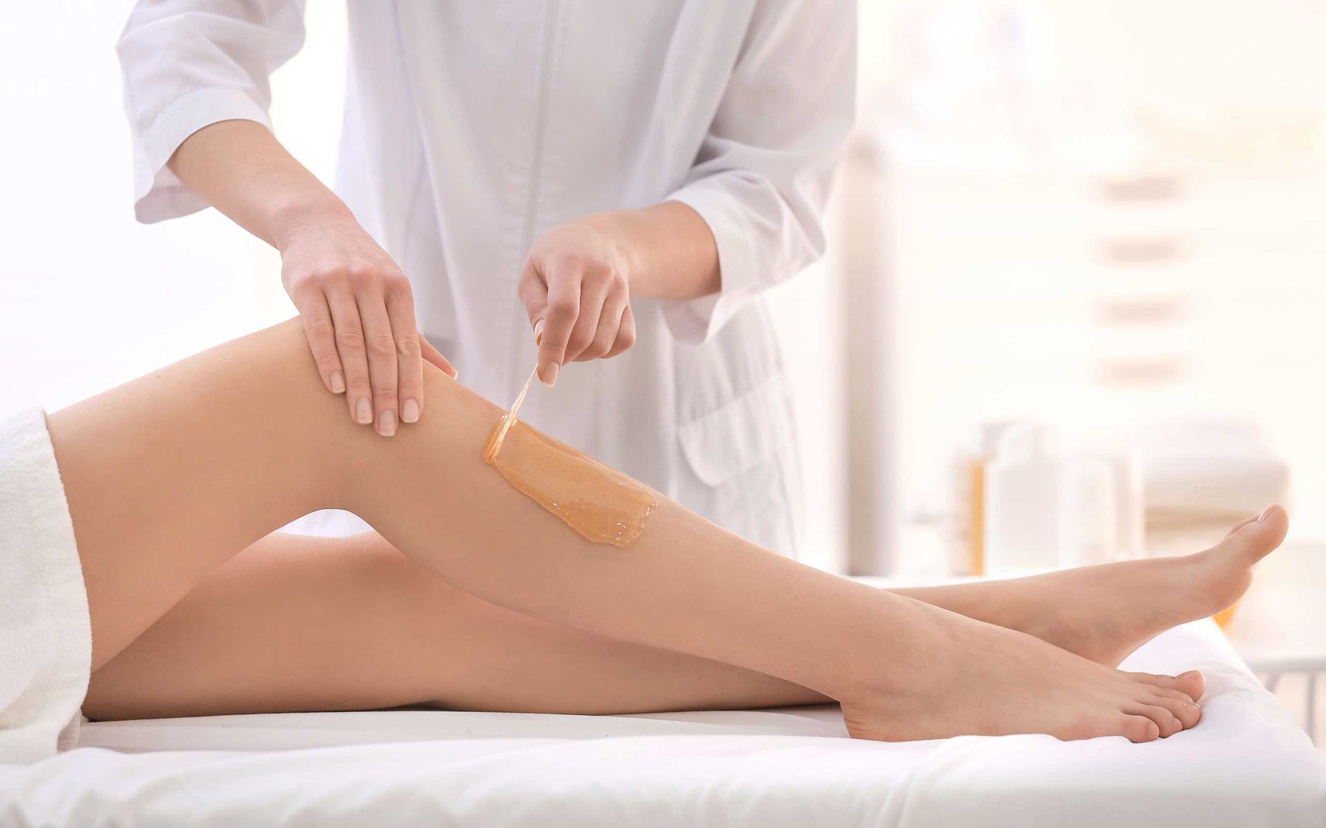 A woman is getting her legs waxed at a beauty salon.