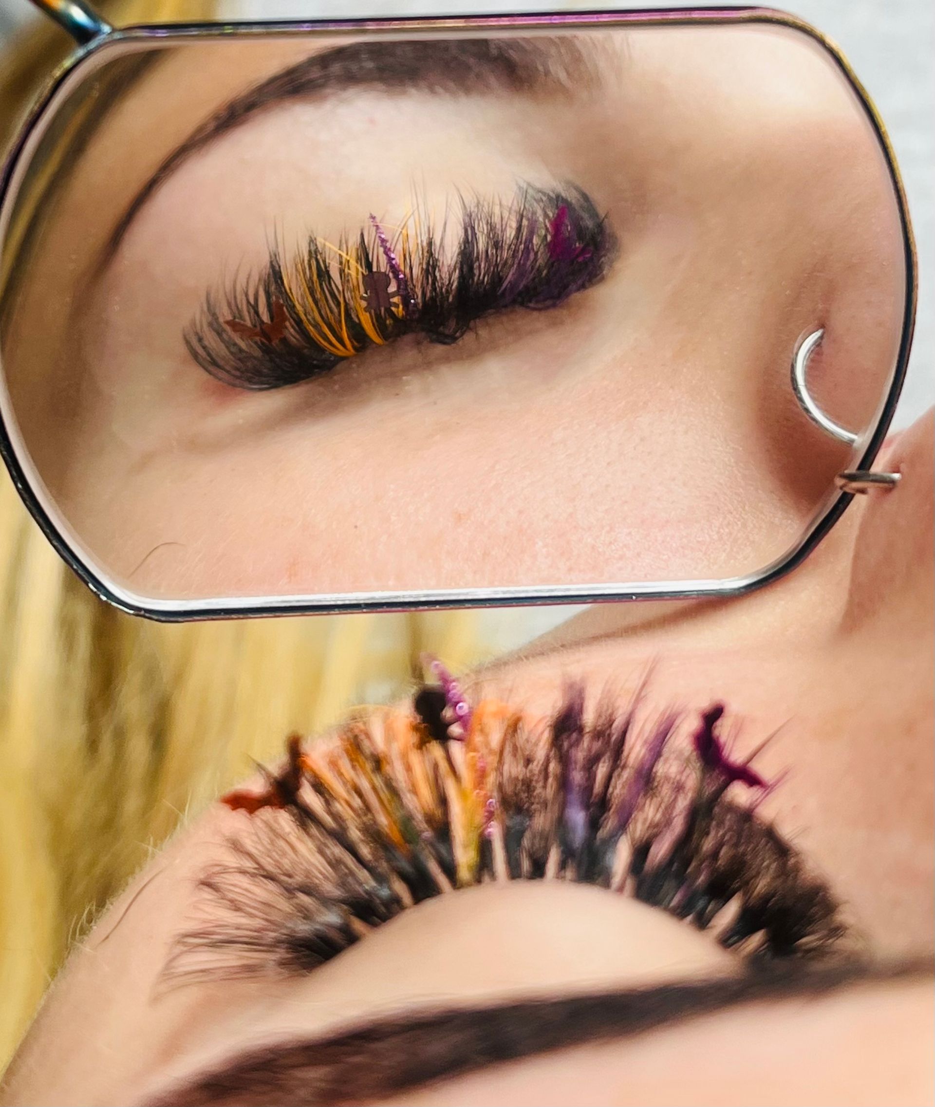 a woman is looking at her eyelashes in a mirror