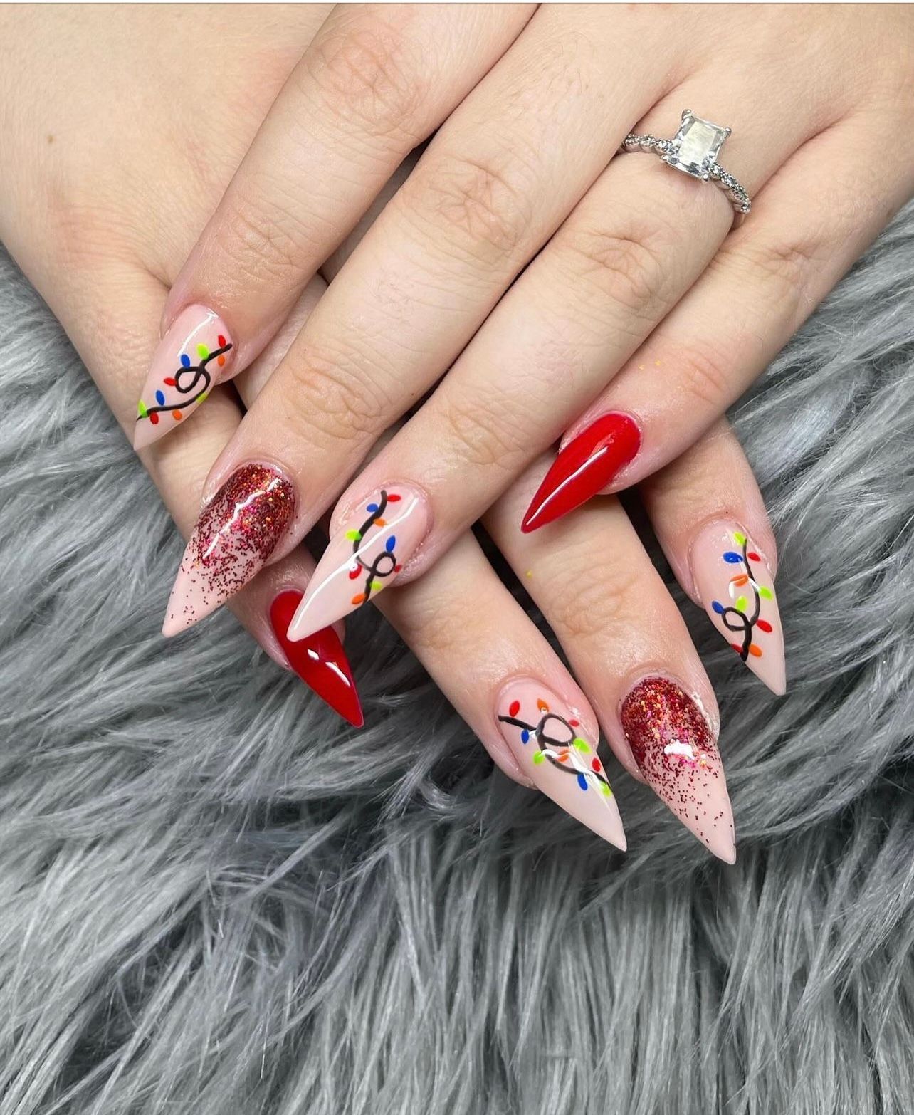 a close up of a woman 's nails with a ring on her finger .