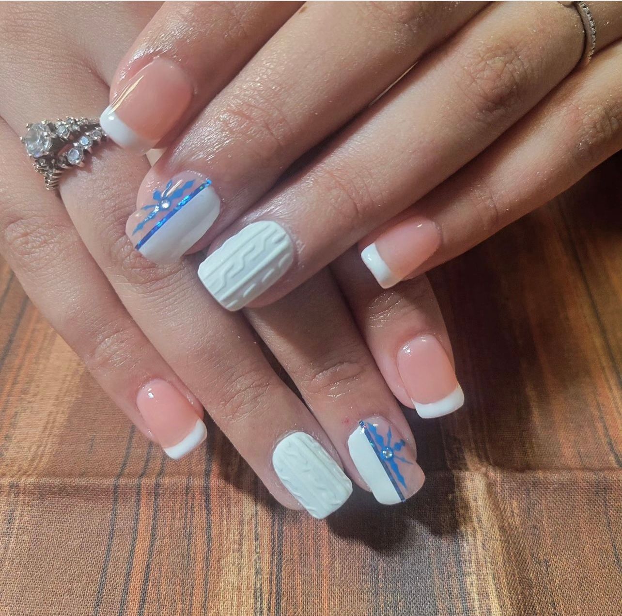 a close up of a woman 's nails with a ring on her finger