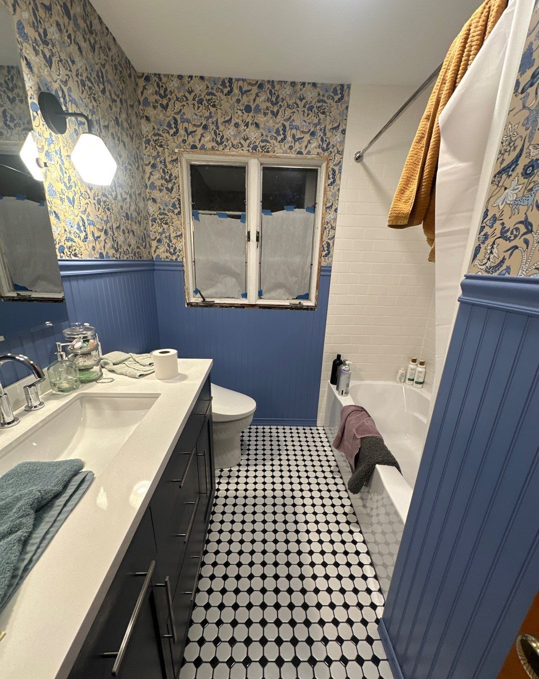 A bathroom with a toilet a sink and a bathtub.