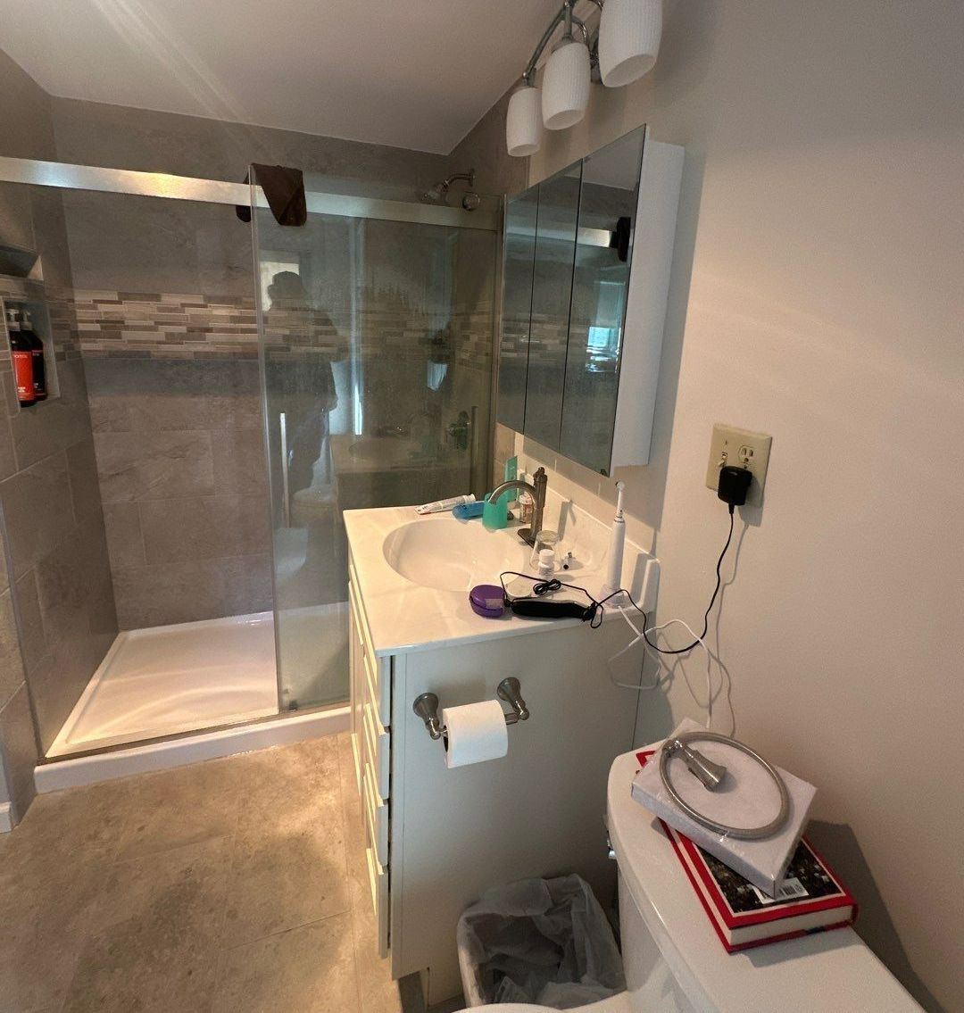 A bathroom with a sink, toilet, and shower.