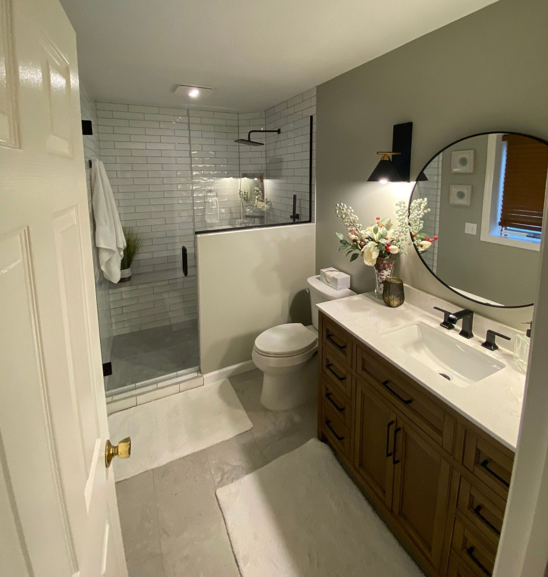 A bathroom with a toilet, sink, and mirror.