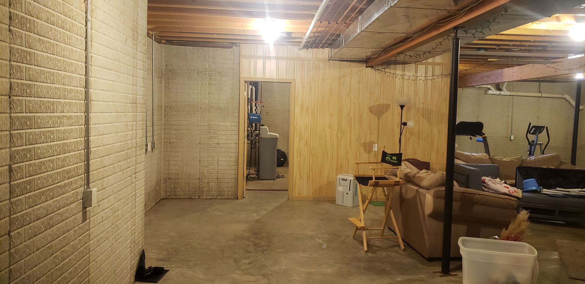 A basement with a couch and a table in it.