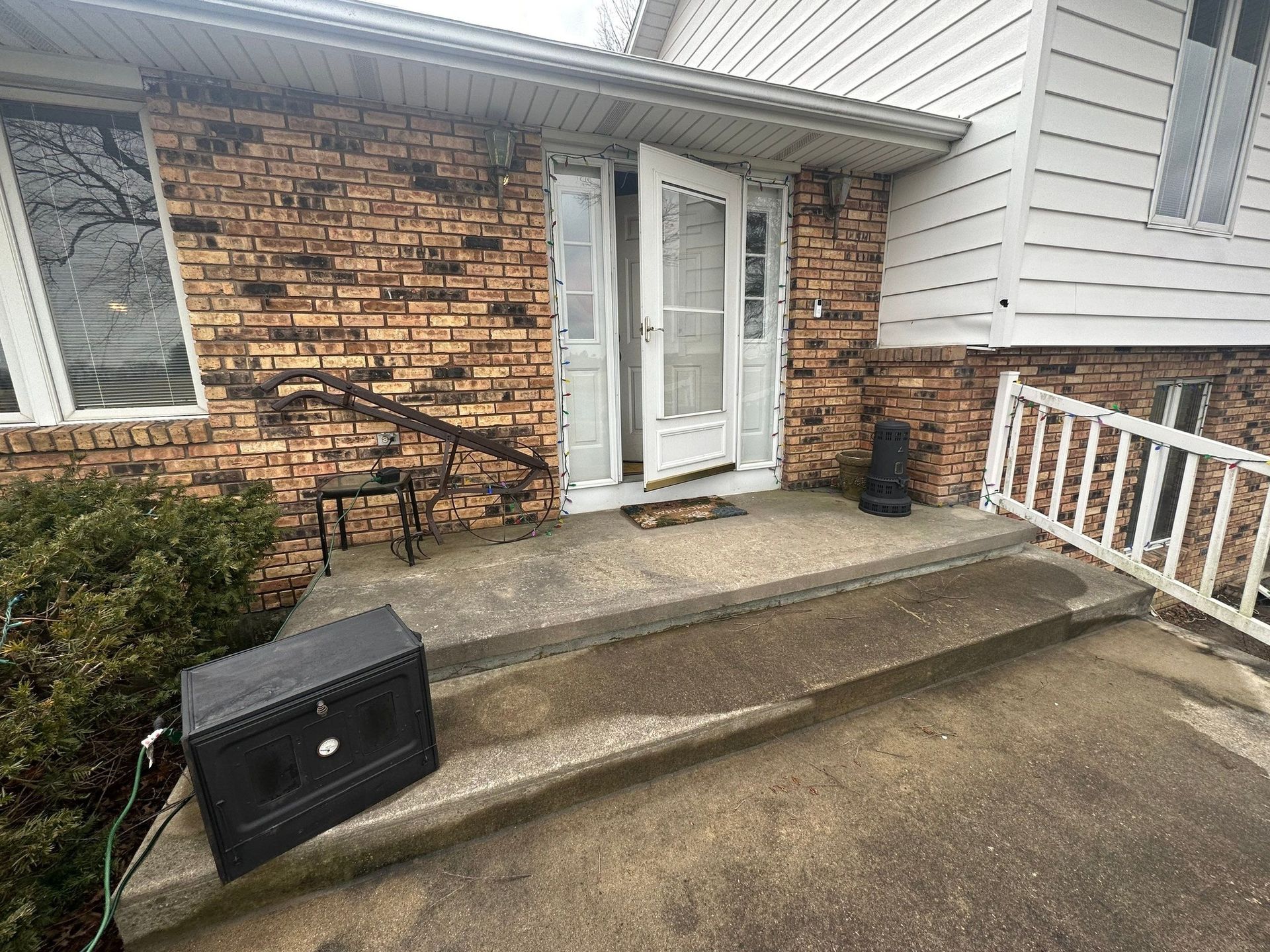 A black box is sitting on the steps of a house.