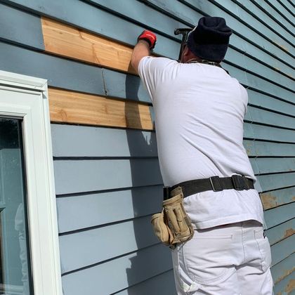 A man is working on the side of a house