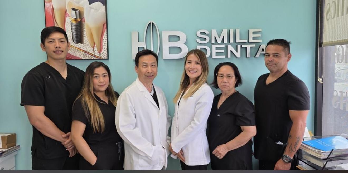Woman at dentist, smiling while doctor holds dental tools. Light-skinned doctor wearing blue gloves and white coat.