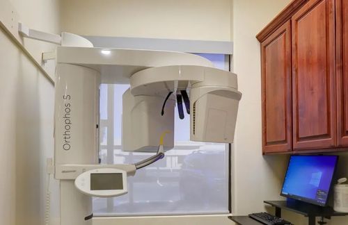 Orthopantomography X-ray machine in a dental clinic beside a computer monitor