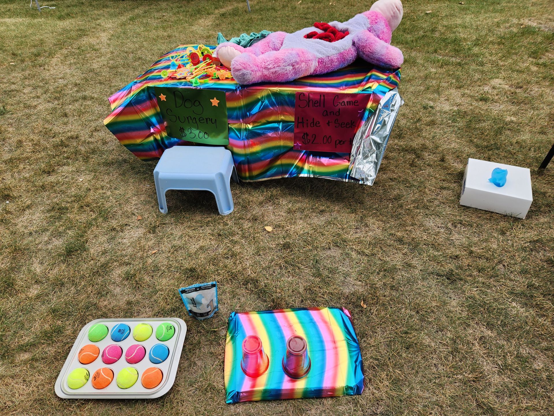 A stuffed animal is laying on top of a table with toys on it.