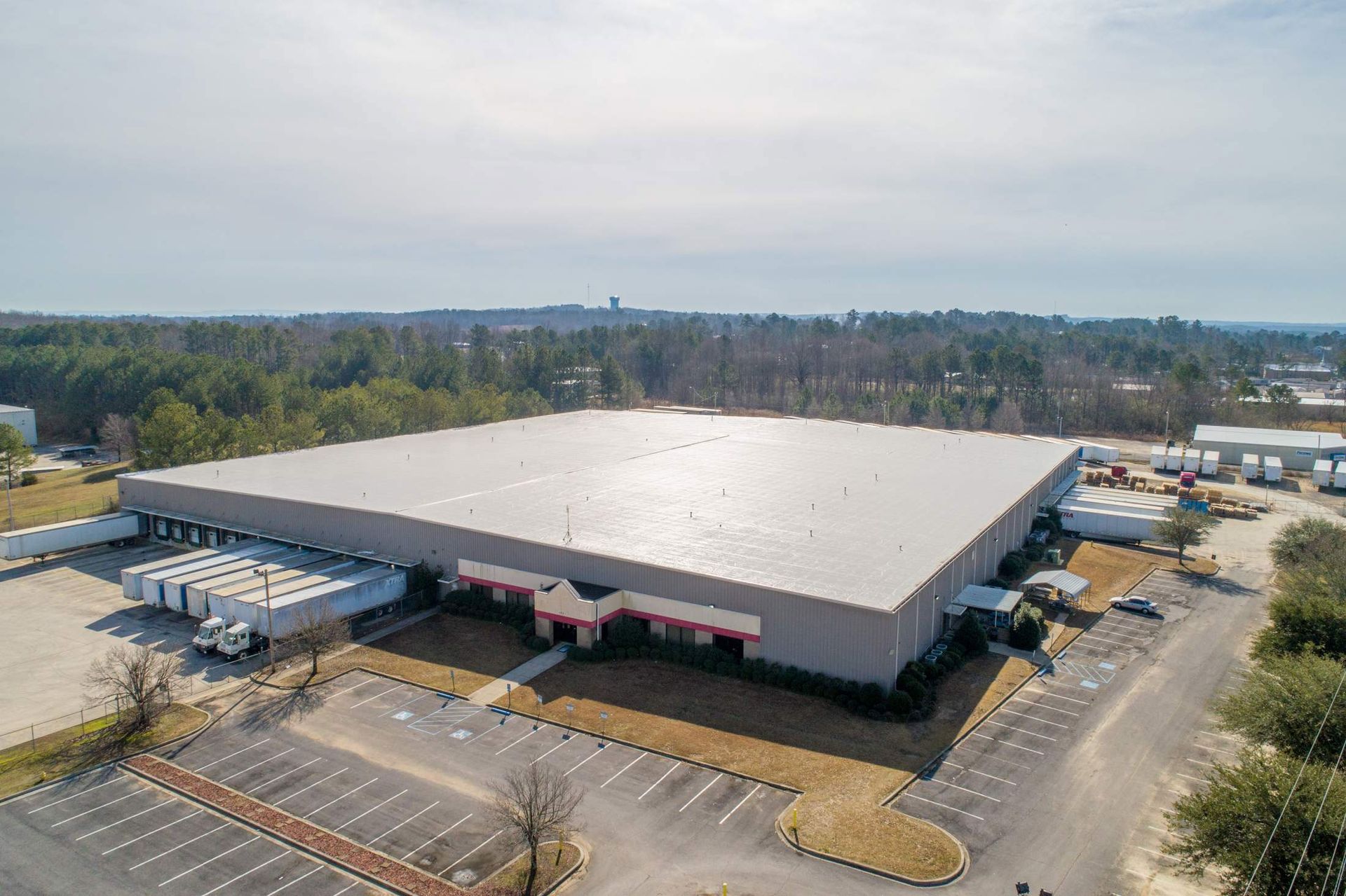 Aerial view of a large industrial warehouse with loading docks and parking lot.