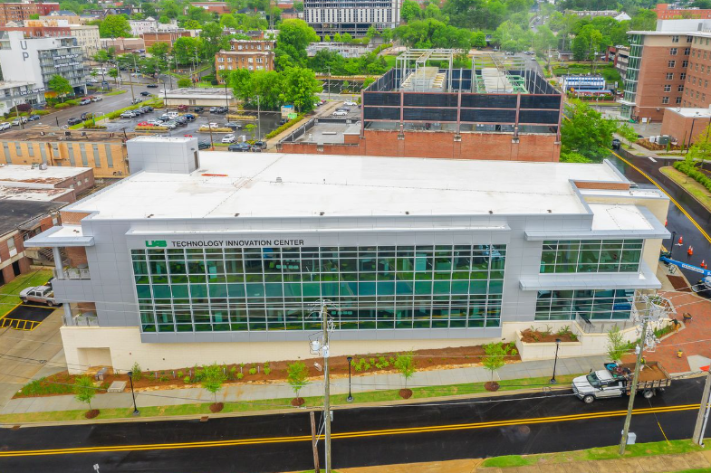 An aerial view of a large building with a lot of windows in a city.