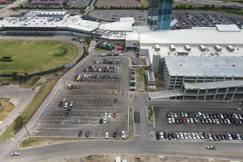 An aerial view of a parking lot in front of a large building