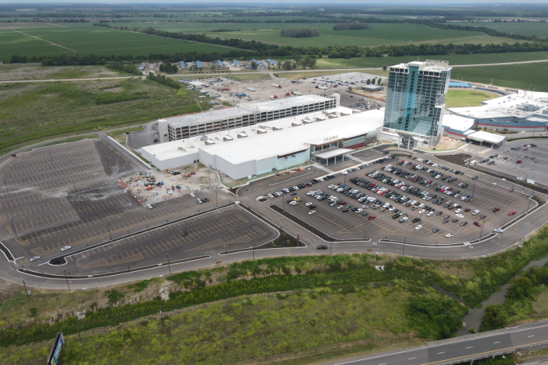 An aerial view of a large building with a lot of cars parked in front of it.