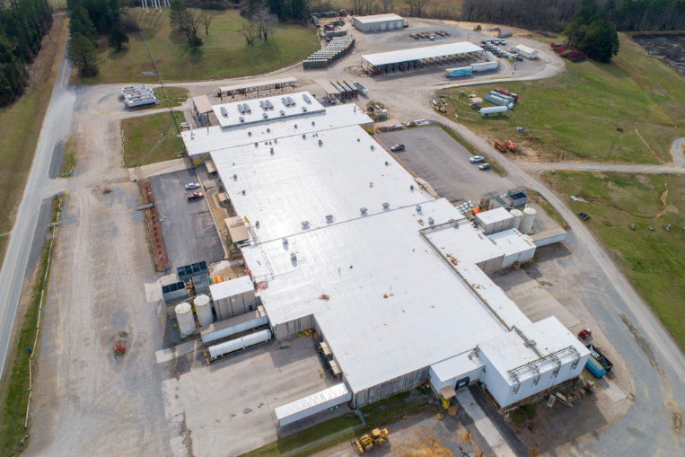 An aerial view of a large white building with a white roof.