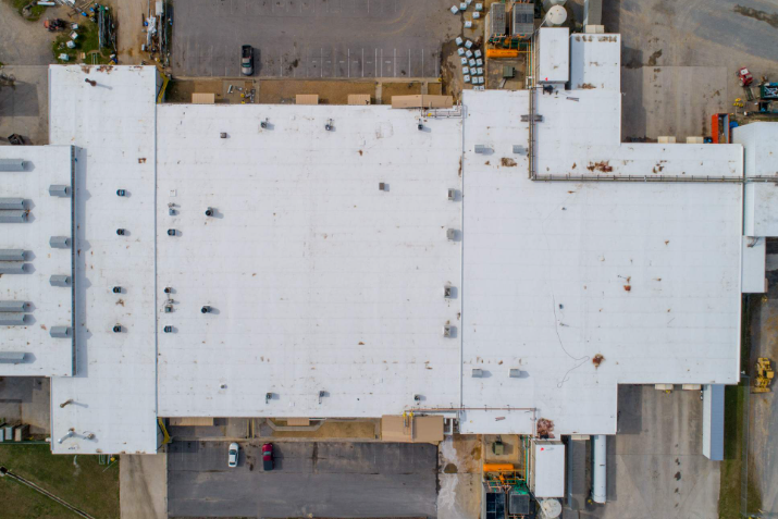 An aerial view of a large building with a white roof.