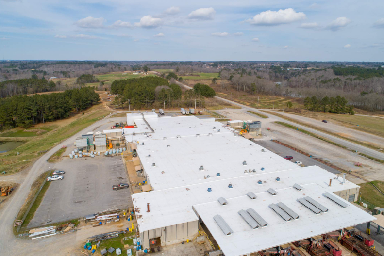 An aerial view of a large building with a white roof.