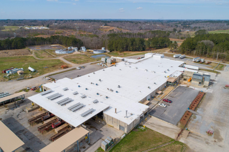 An aerial view of a large building with a white roof.