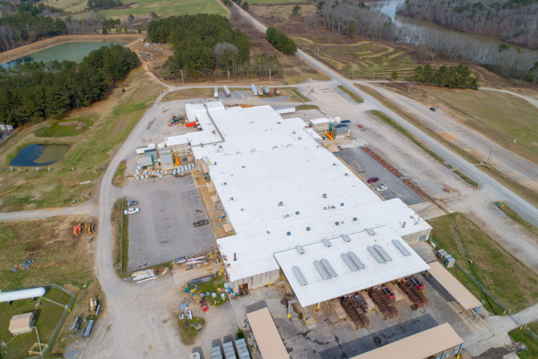 An aerial view of a large building with a white roof.