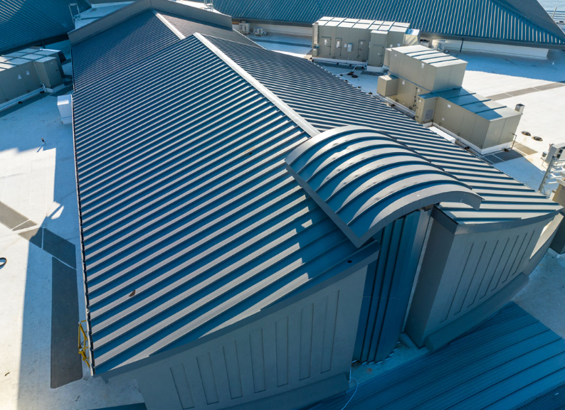 An aerial view of a large building with a blue roof.