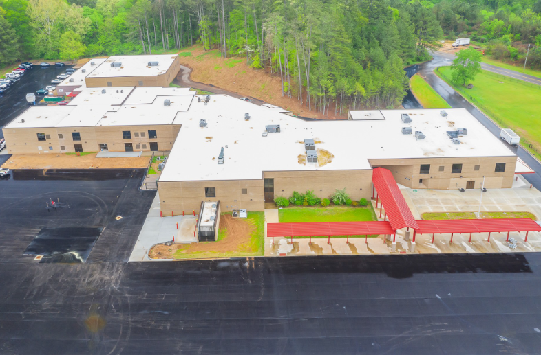 An aerial view of a large building with a red walkway leading to it.