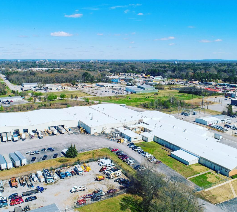 An aerial view of a large building with a lot of cars parked in front of it.