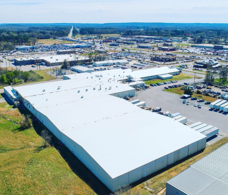 An aerial view of a large white building with a white roof.