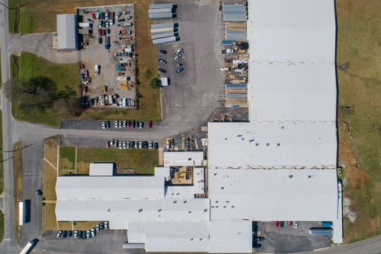 An aerial view of a large building with a white roof