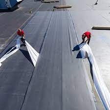 A couple of men are working on a roof.