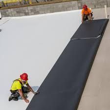 A couple of men are working on a roof.