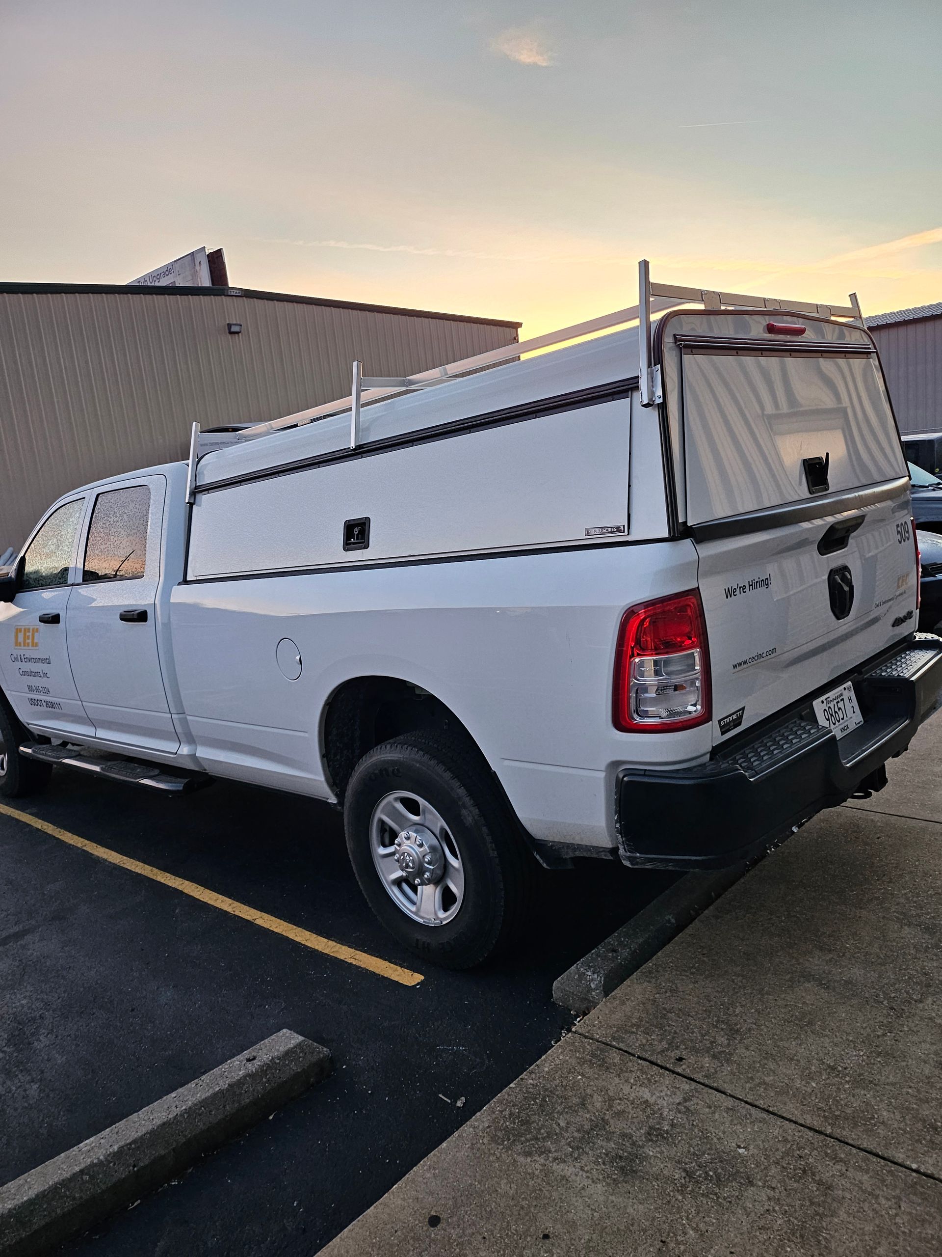 White Ram pickup truck with a white utility bed parked outdoors at dusk.
