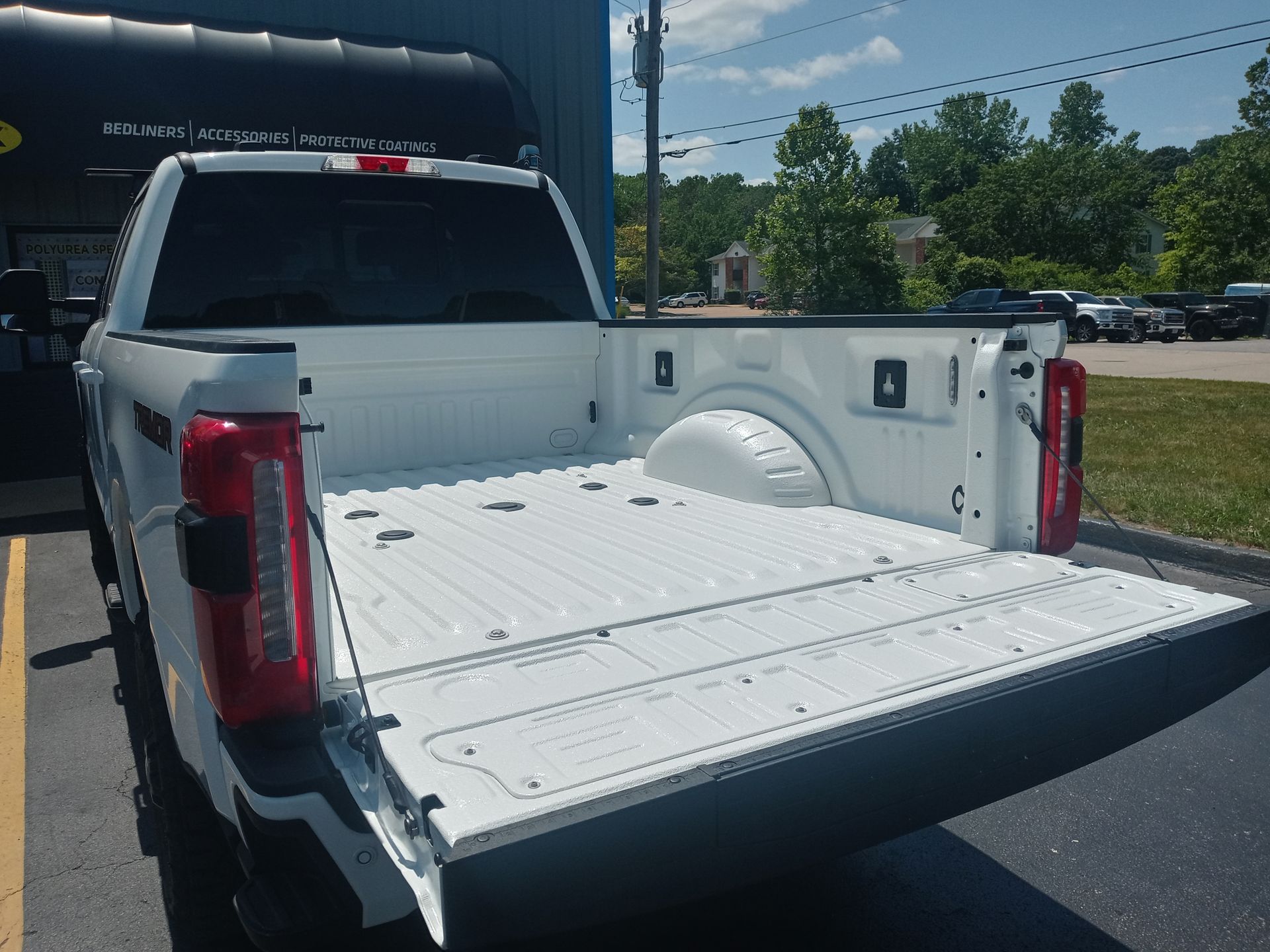 White pickup truck bed with open tailgate.