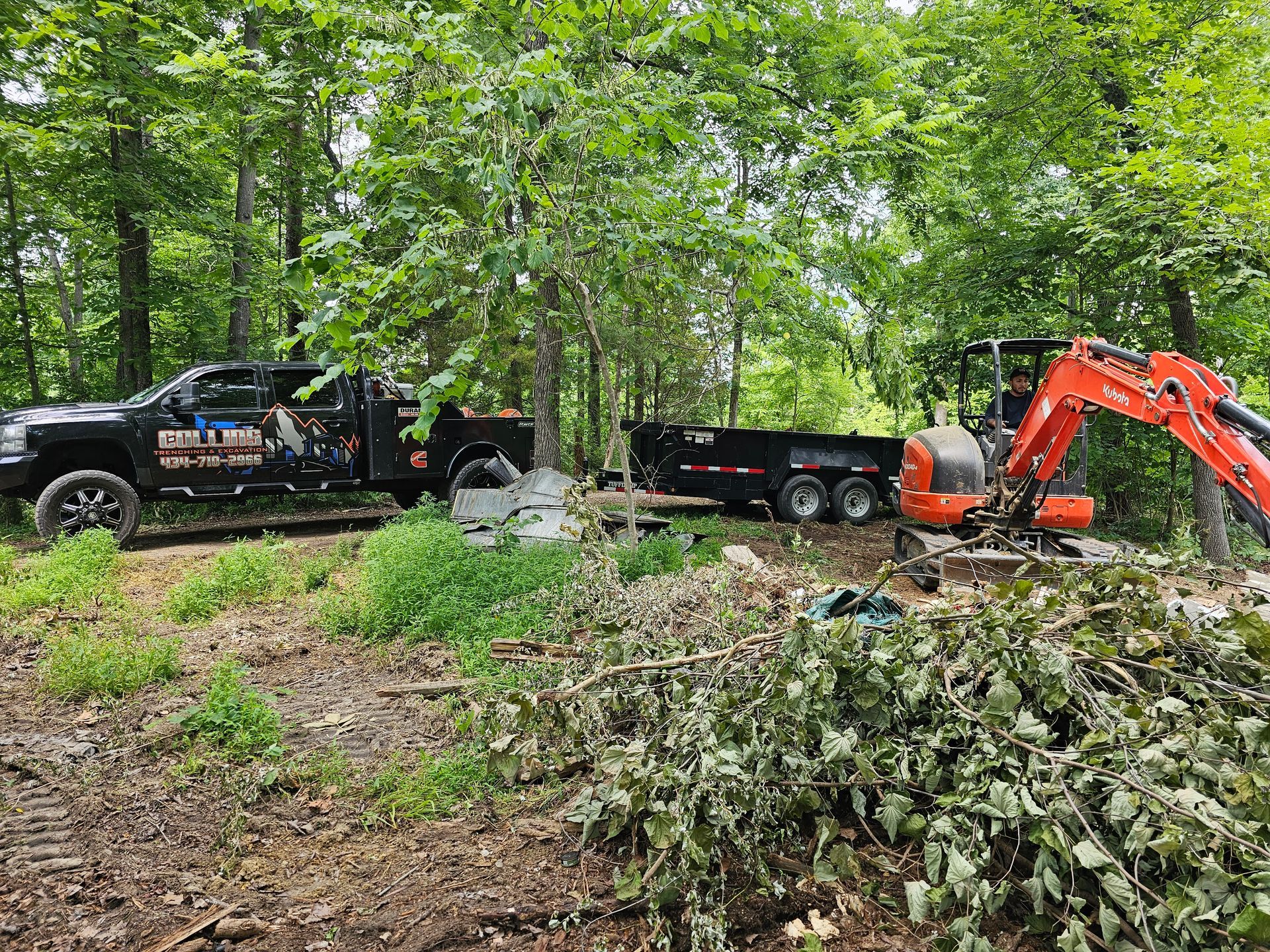 A truck with a trailer attached to it is driving through a forest.