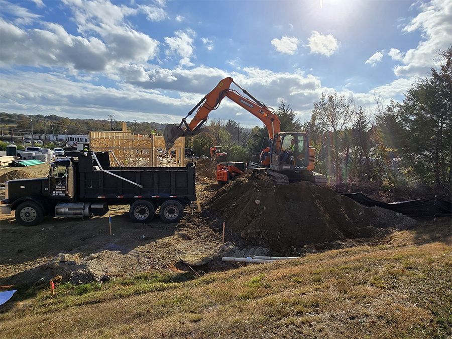 An excavator is loading dirt into a dump truck at a construction site.