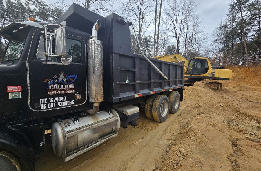 A dump truck is parked on the side of a dirt road.